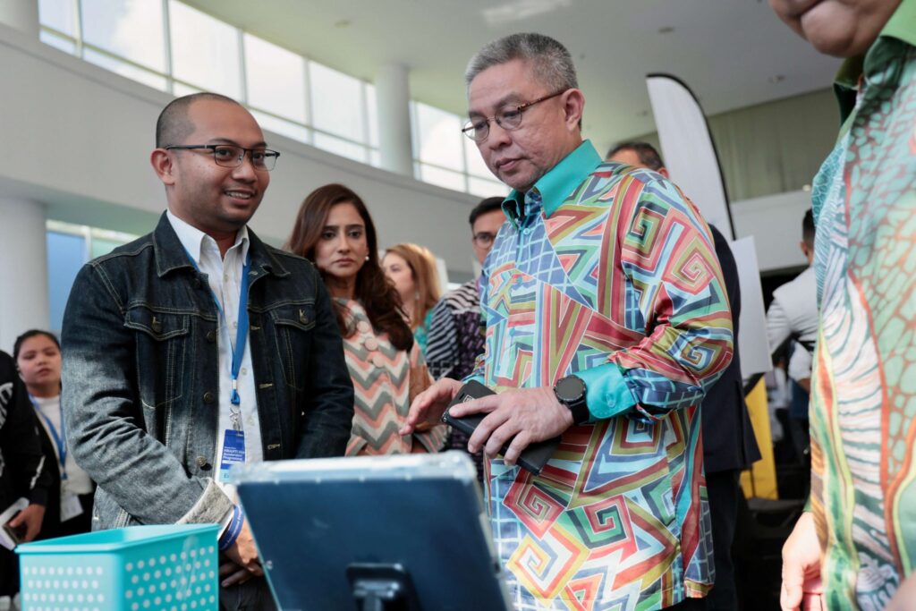 MRANTI GAP event with a Malaysian minister viewing a startup demo at an exhibition booth