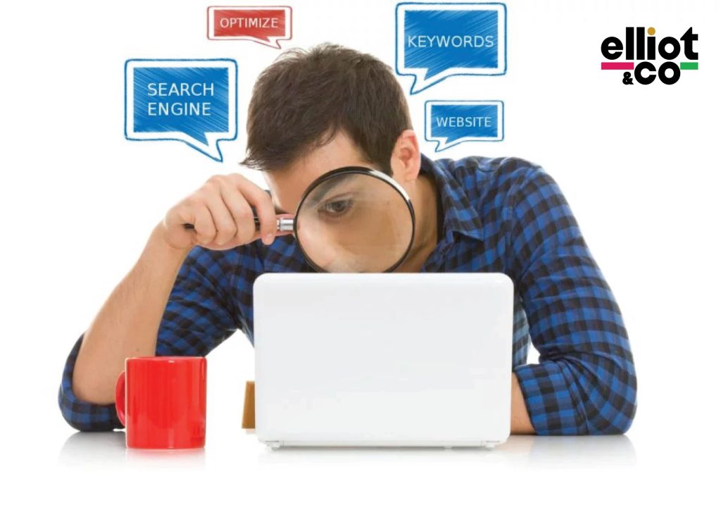 Man peering through magnifying glass at laptop with SEO keyword speech bubbles overhead