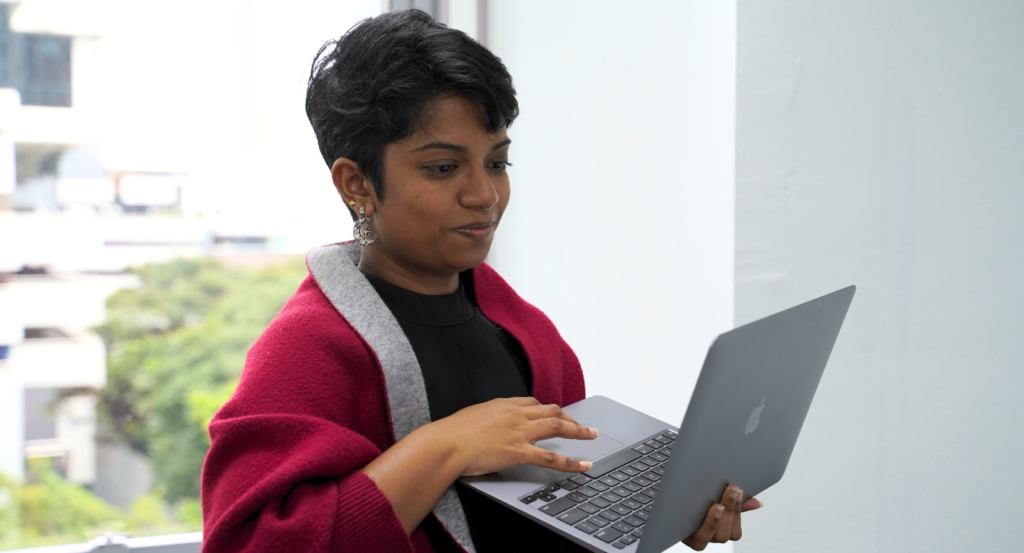 Elliot & Co. PR consultant working on a laptop in a bright Malaysia office