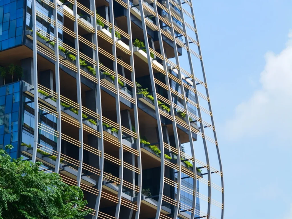 Curved green-accented facade of Singapore's Parkroyal Collection building against a blue sky