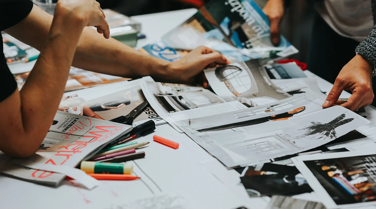 Creative team laying out magazine clippings and brand moodboard materials on a table