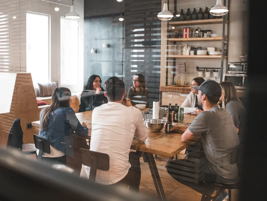 Group of creators and marketers laughing around a cafe table during a content strategy meetup