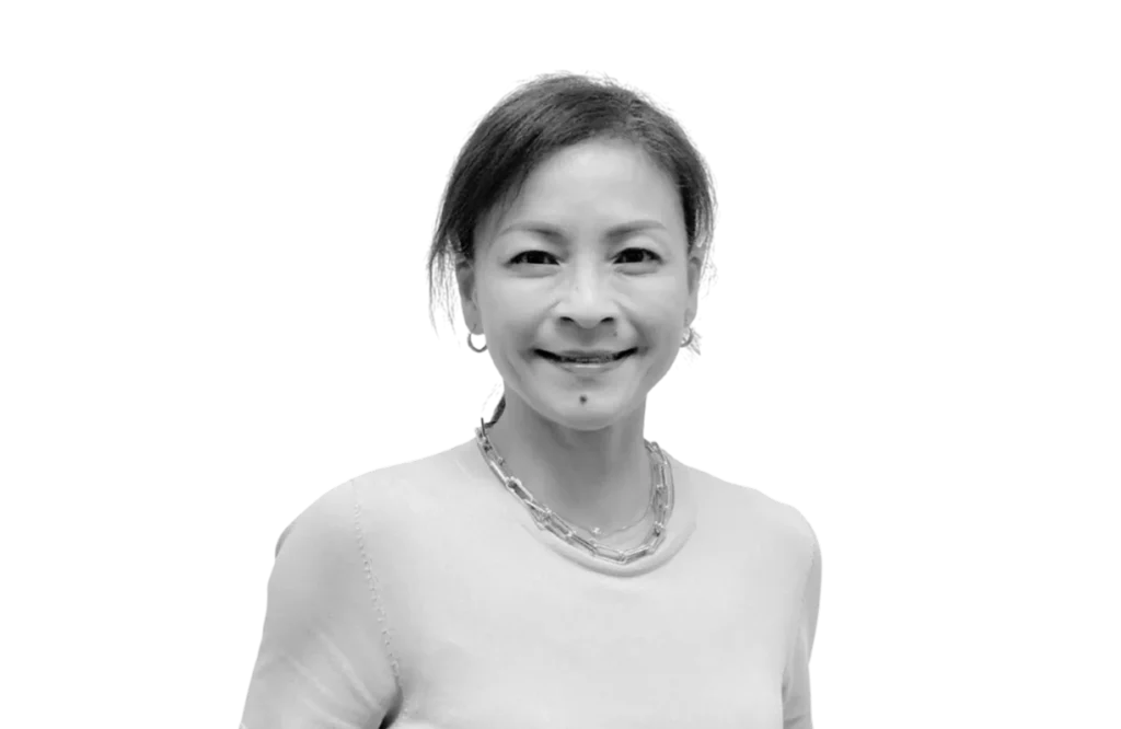 Mayda, Managing Director at Elliot & Co., smiling in a light knit top