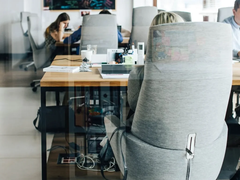 Team members collaborating at shared desks in an open-plan coworking space