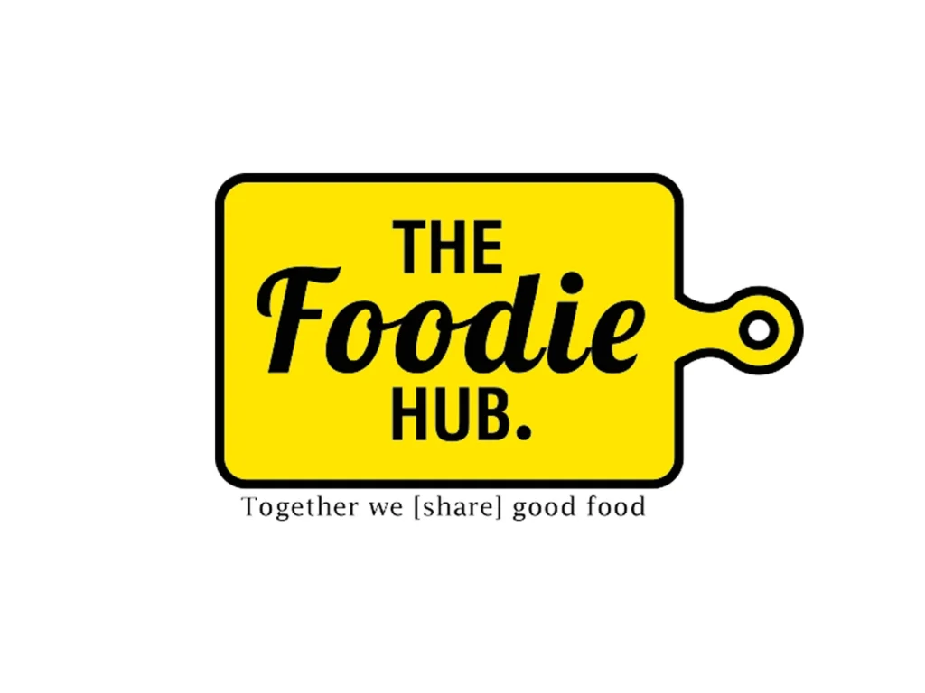 The Foodie Hub logo on a yellow cutting board with tagline Together we share good food